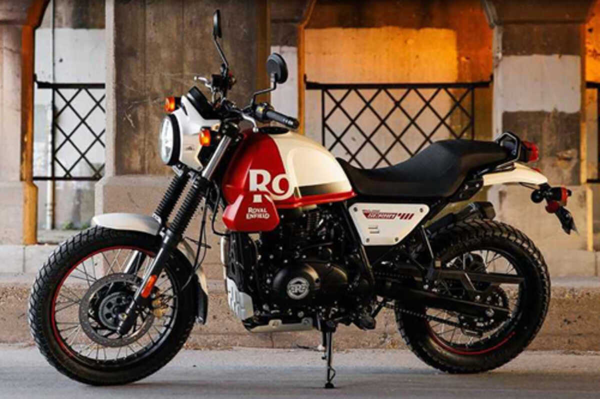 Foto lateral da Royal Enfield Scram 411. Ela tem uma pintura nas cores vermelha e branca.