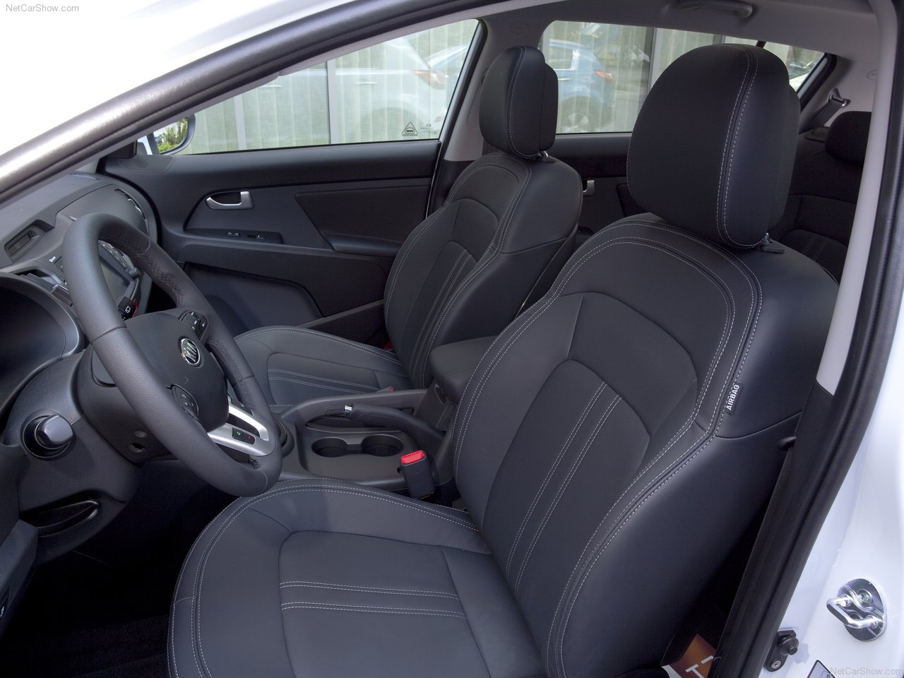 Foto exibindo os bancos dianteiros do Kia Sportage.
